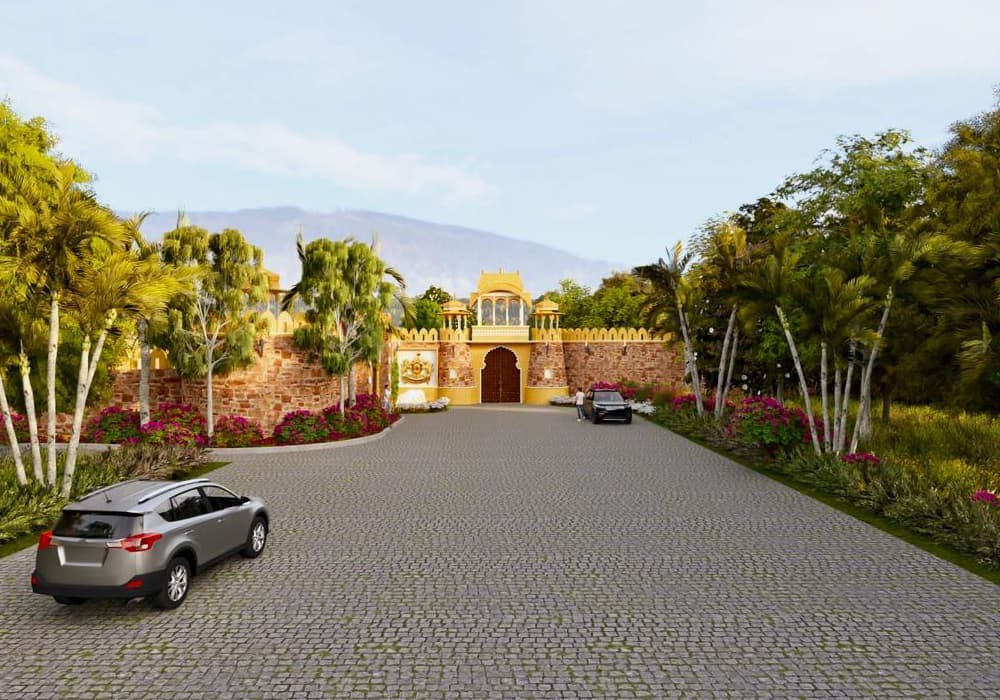 Cobblestone entrance driveway lined with flowering plants leading into the resort